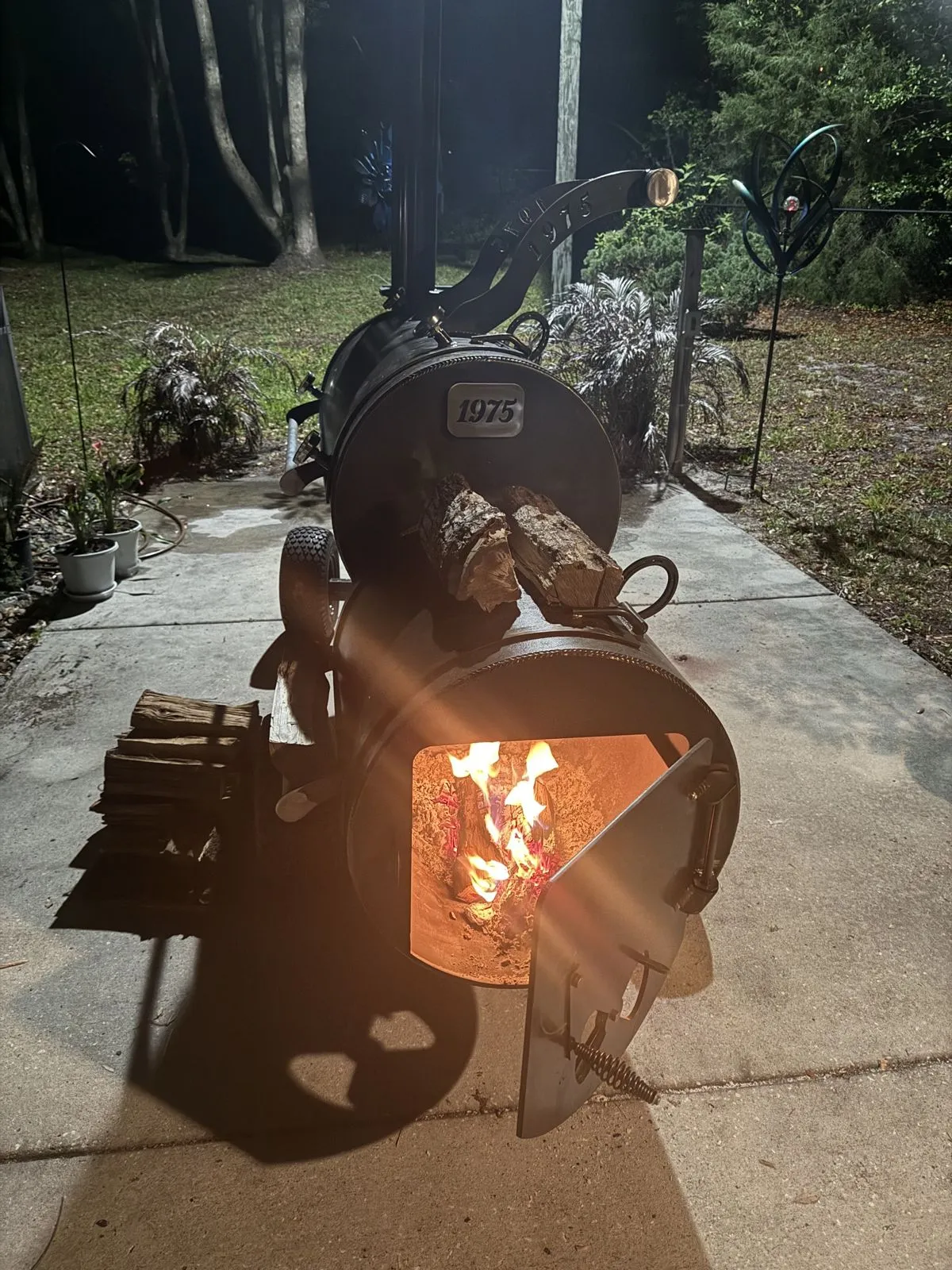 A fire burning in a metal fire pit at dusk.